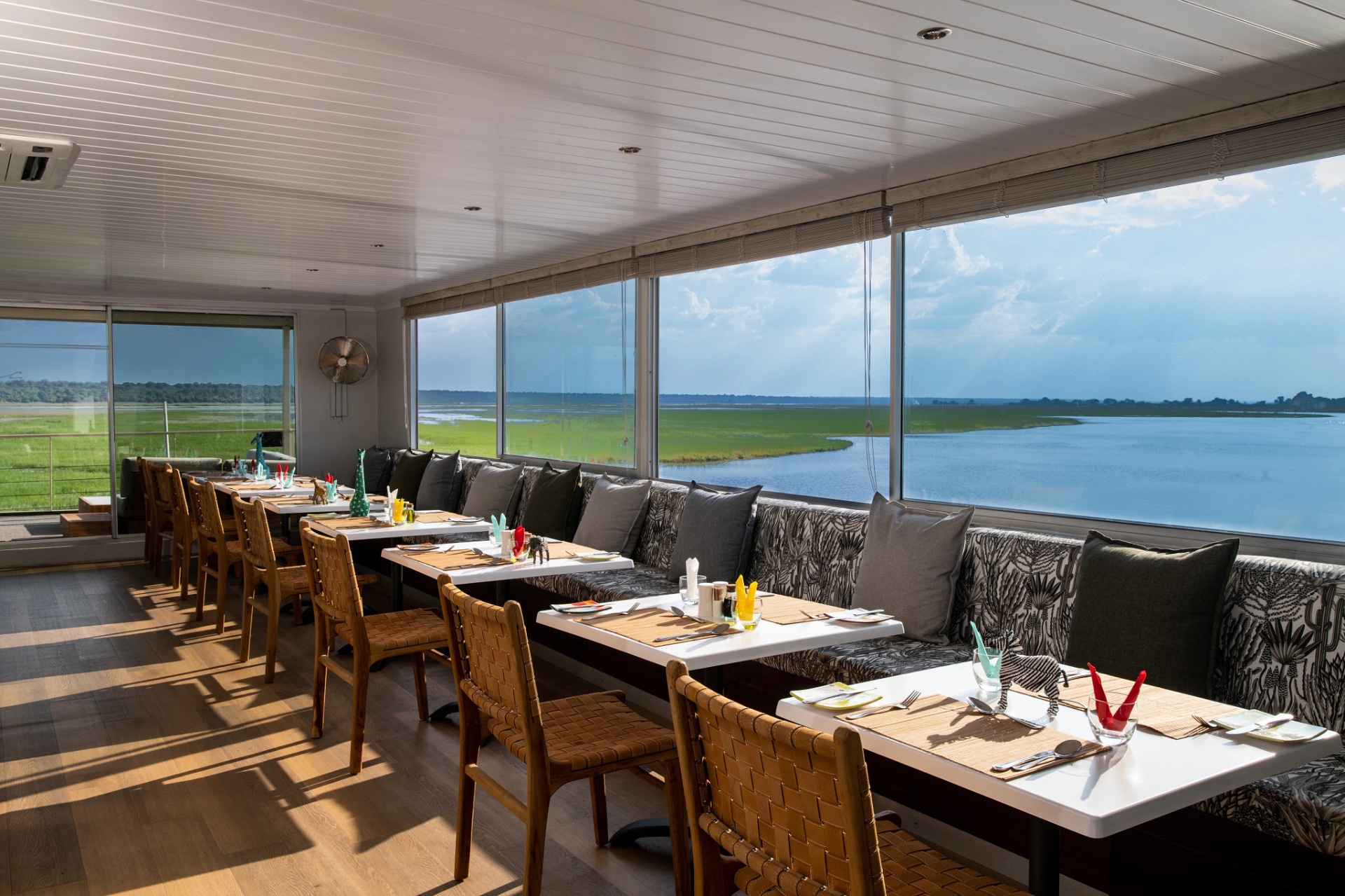Dining room aboard Zambezi Queen with river views on both sides