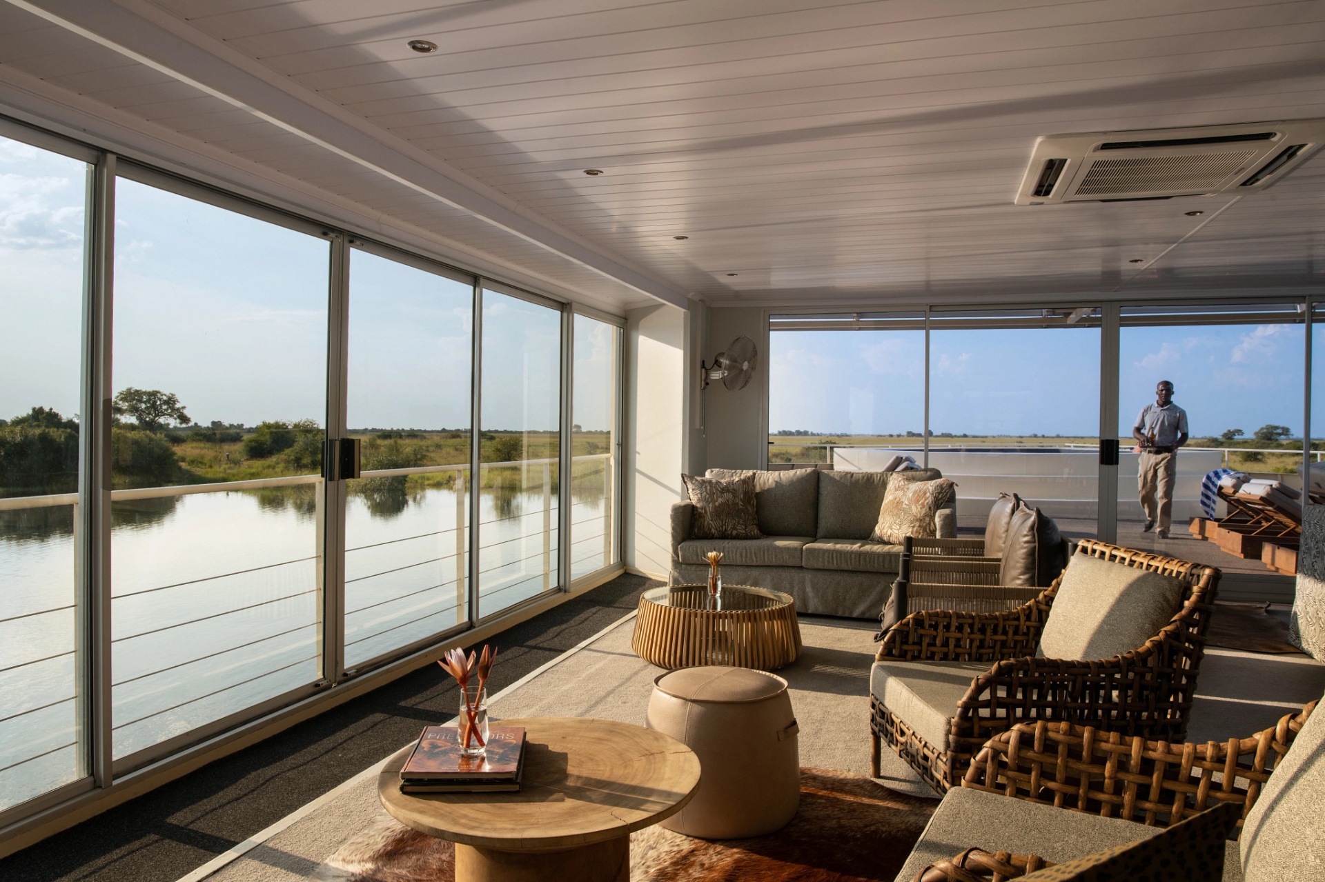 Panoramic lounge aboard Zambezi Queen at golden hour